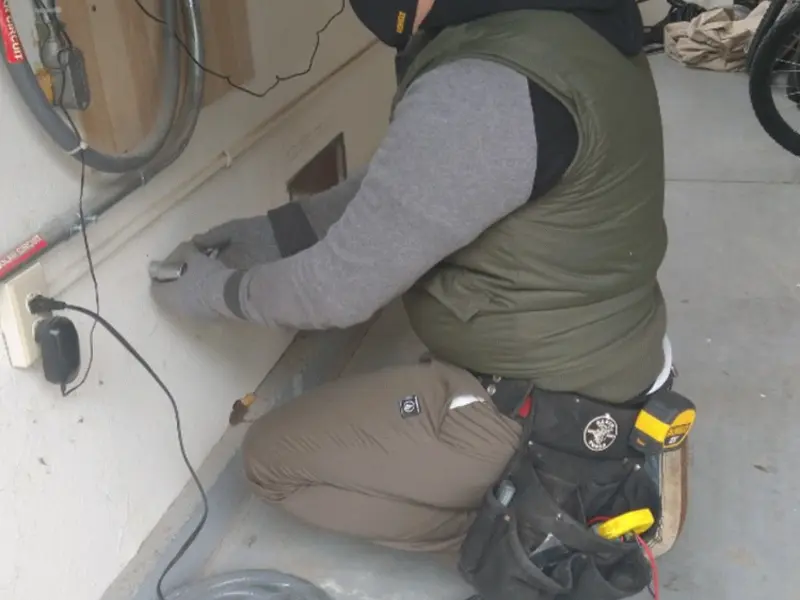Electrician performing outlet wiring in a Lenexa garage